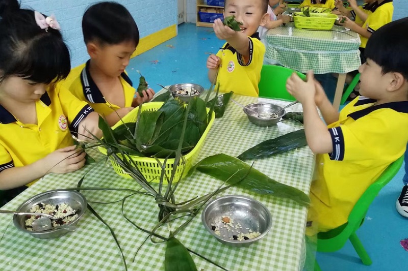 幼儿在学习包粽子-自然教育课程-苏仙区第九幼儿园